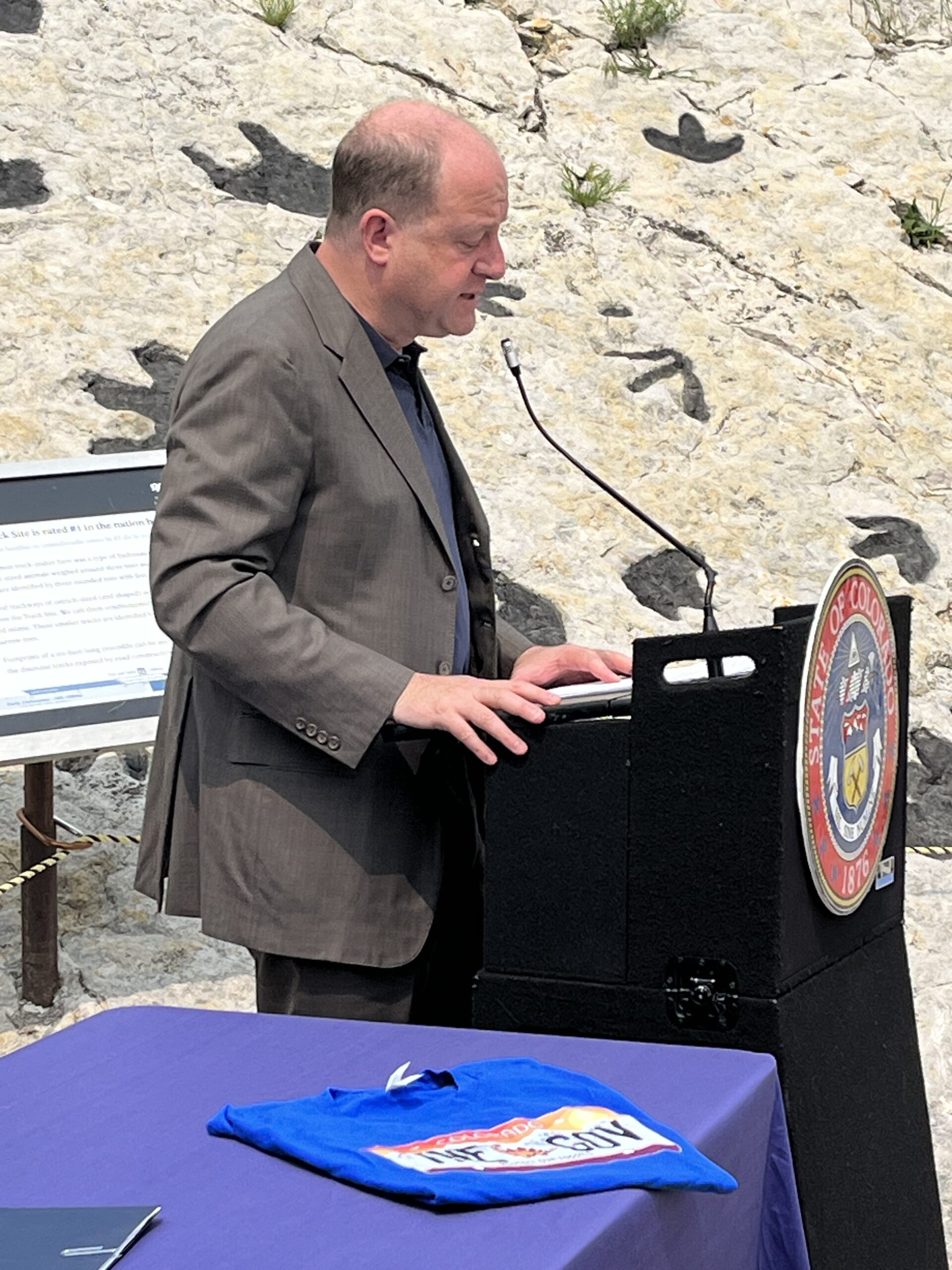 Colorado Governor Jared Polis speaks at Dinosaur Ridge prior to signing the new Stegosaurus License Plate bill into law on May 22, 2023.