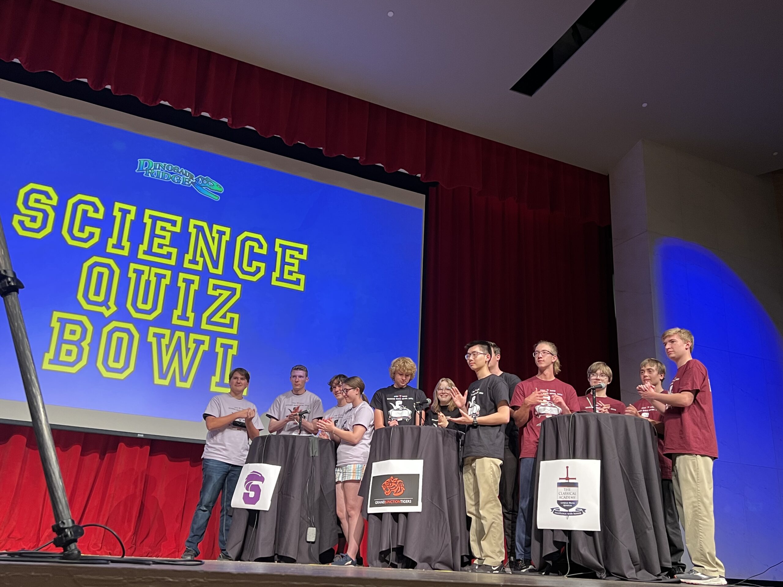 Top 3 high school teams on stage for Science Quiz Bowl finals in 2023.