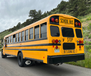 School bus drives up Dinosaur Ridge.